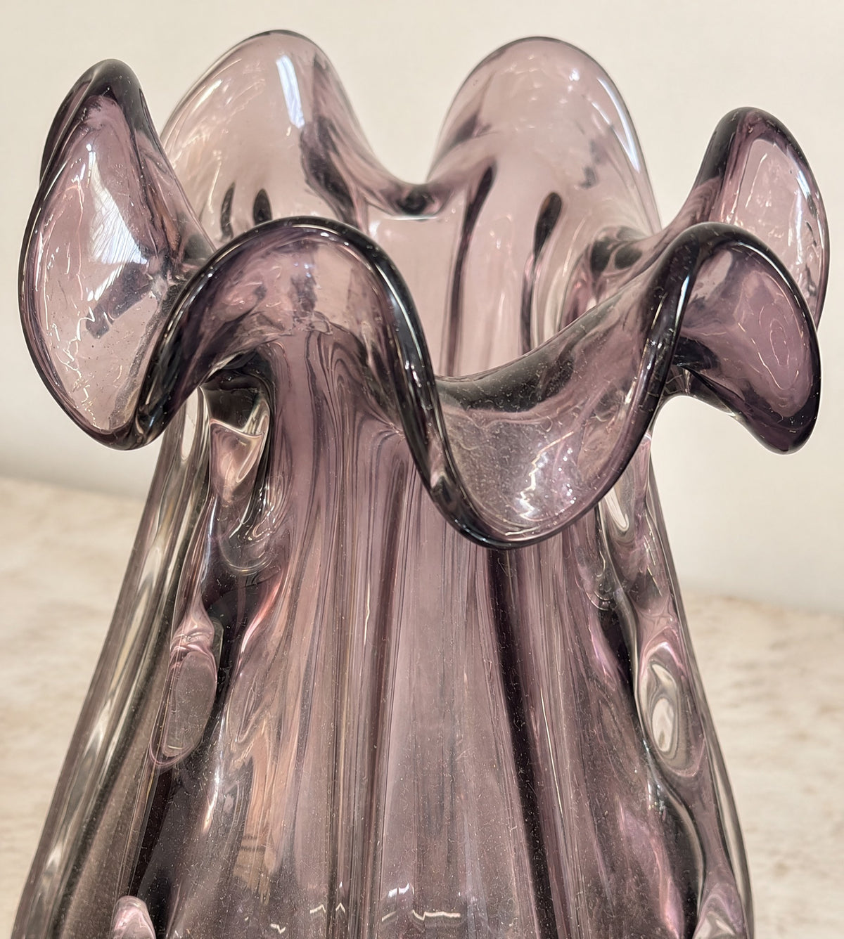 Close-up of the folded ruffled rim of the big amethyst glass vase