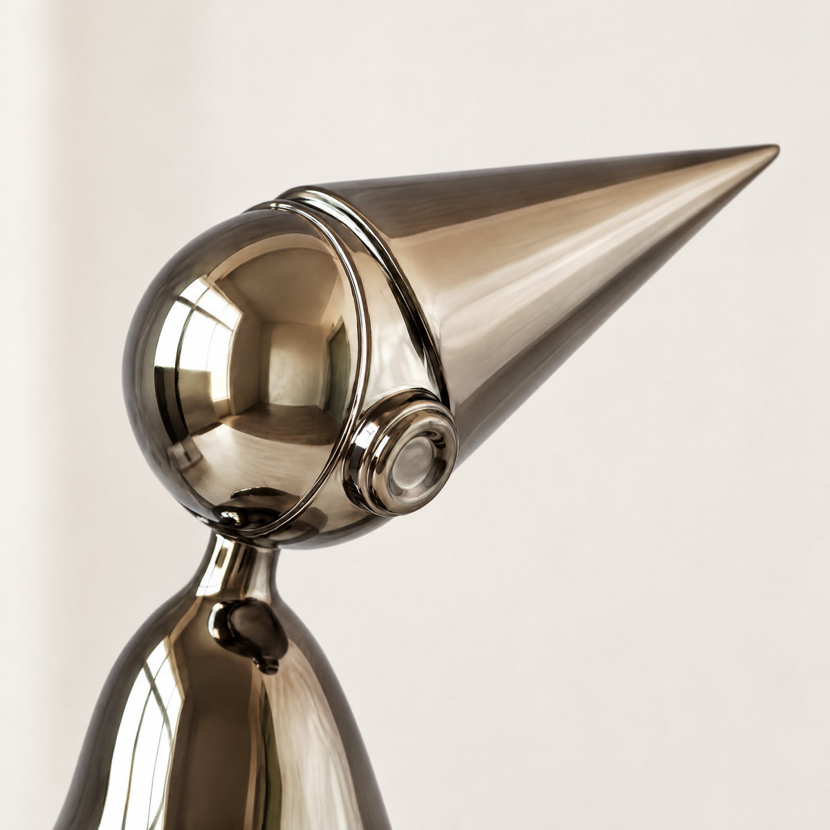 Close-up of the gunmetal shelf-sitter's round head, ear-piece and pointed cone hat