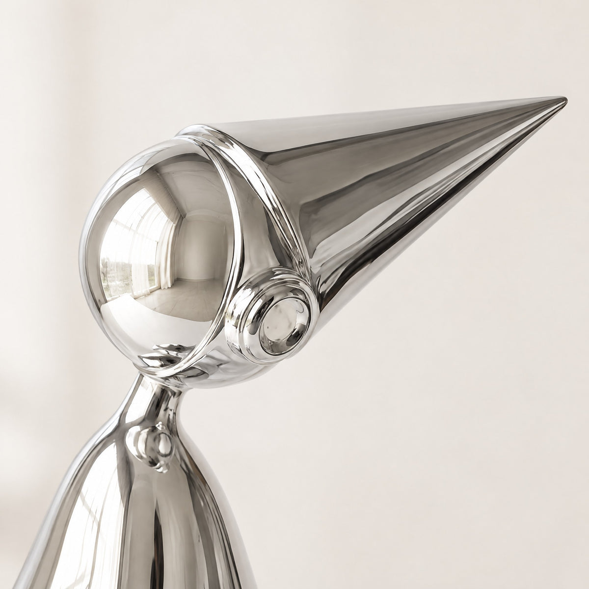Close-up of the silver chrome shelf-sitter's round head, ear-piece and pointed cone hat