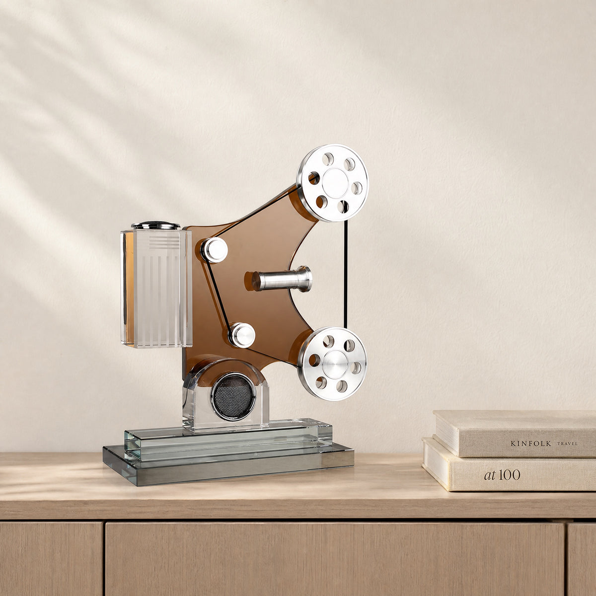 Crystal film projector sculpture with amber panel and polished metal reels on a walnut console