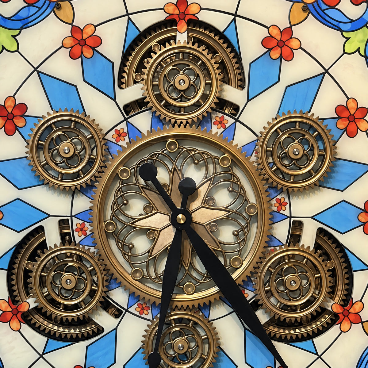 Close-up of the Garden Aura wall clock centre: gold gears and filigree wheel over coloured glass