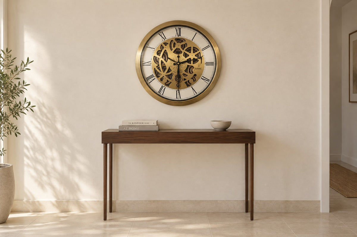 Golden Kinetic 64 cm wall clock hung above a slim walnut console in an entrance hall