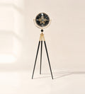 Shadow Line tripod floor clock with black moving-gear dial in a gold-finish ring on slim black legs