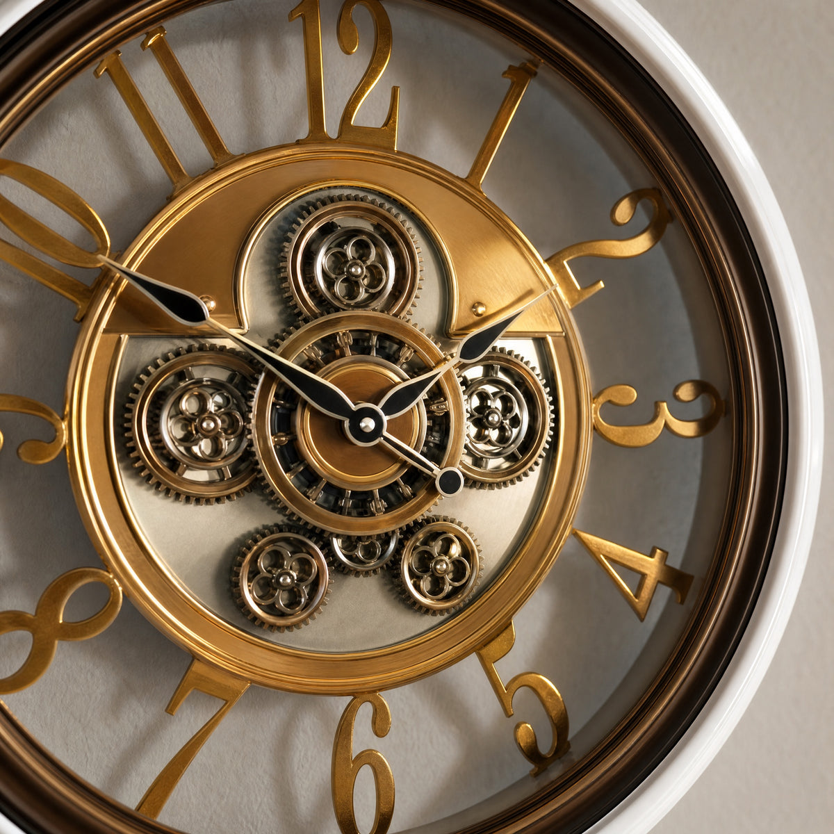 Close view of the Snow Frame clock centre: gold gear plate with five small gears around a central gear ring, black spade hands