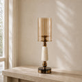 Soluxe onyx marble hurricane candle holder with amber glass shade on an ivory travertine console