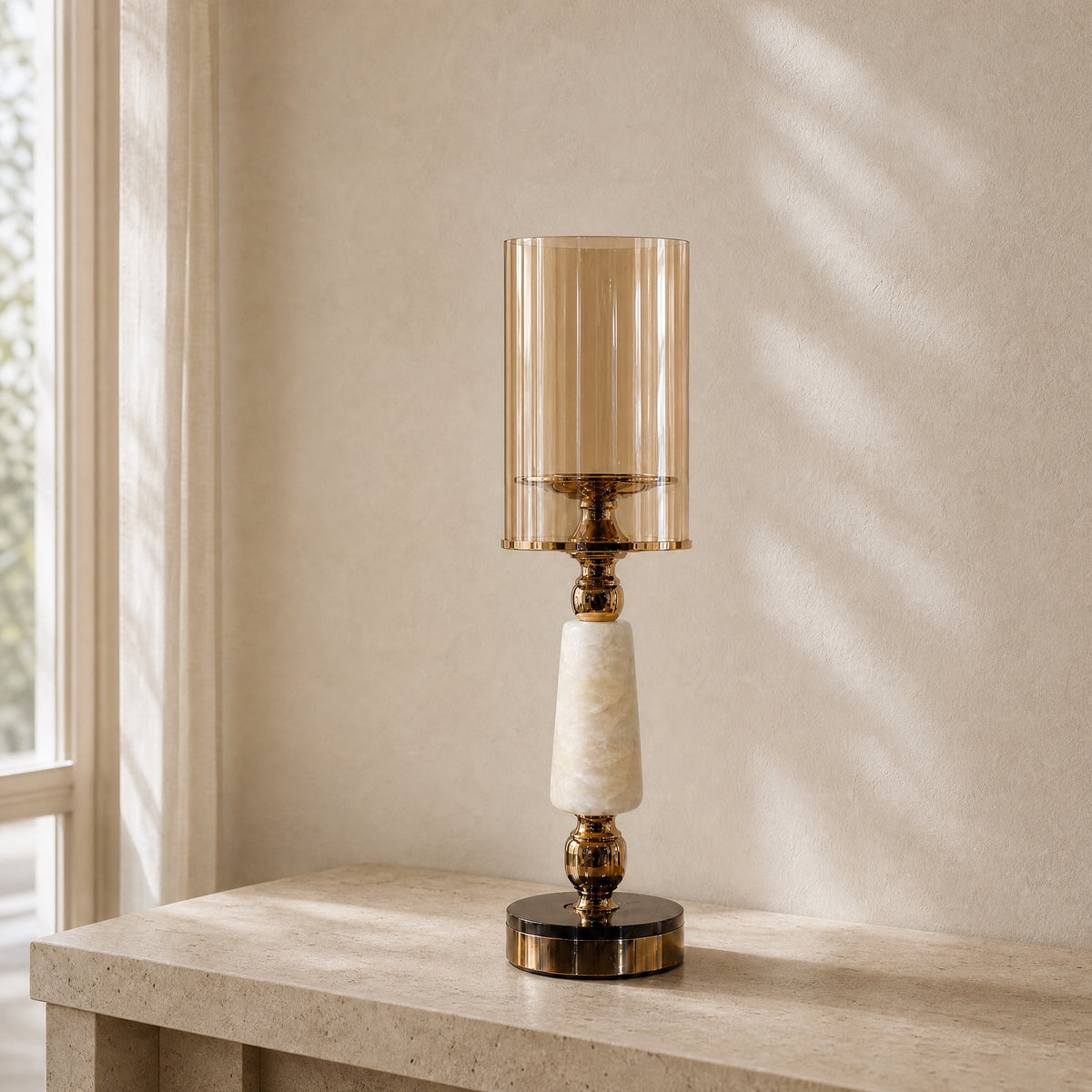 Soluxe onyx marble hurricane candle holder with amber glass shade on an ivory travertine console
