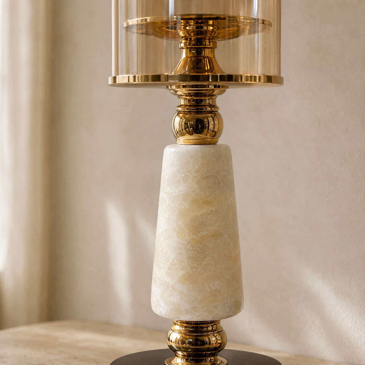Close-up of the onyx marble column and gold-finish metal collars of the Soluxe candle holder