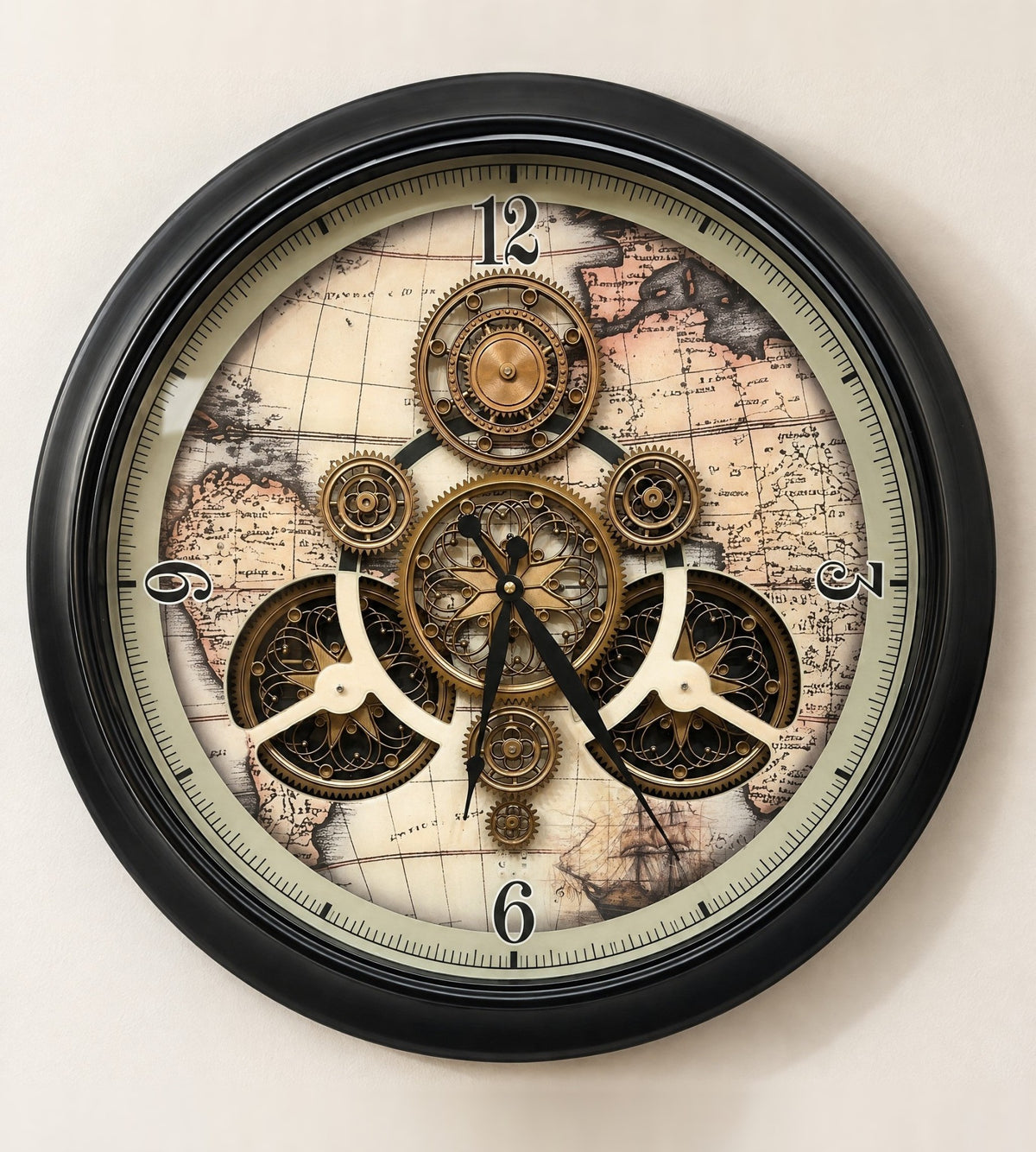 Traveler's Gear wall clock with an antique world map dial and gold gears in a black metal frame, front view on an ivory wall