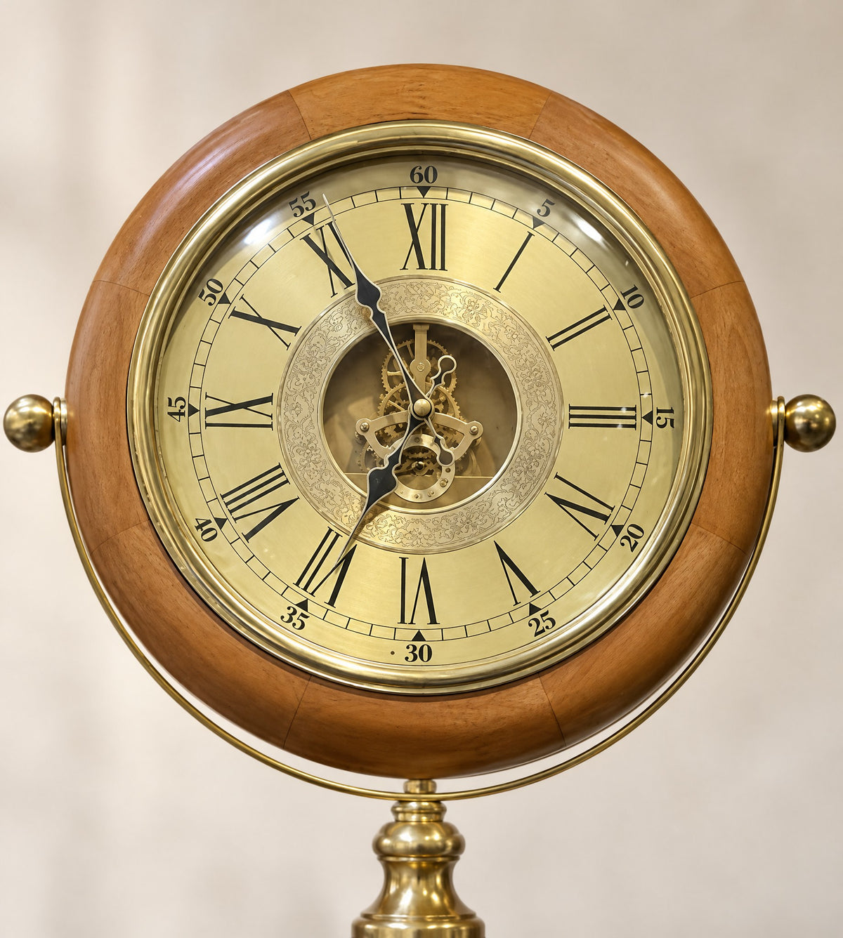 Close-up of the champagne-gold dial with Roman numerals and open brass gears in a wood frame