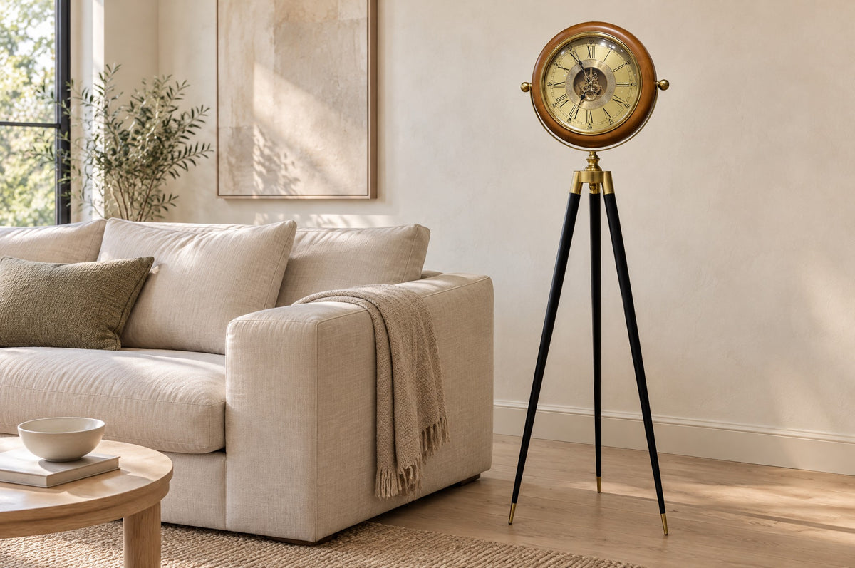 Wood and brass tripod floor clock beside a linen sofa in a light living room